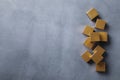 Golden cubes on grey table, flat lay. Space for text