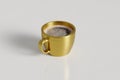 Golden cup with strong coffee on a white background, studio shooting