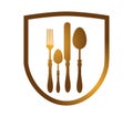 Golden cutlery logo. Spoon fork knife on a shield