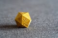 Golden 3D printed d20 RPG game dice on a bed object macro detail, extreme closeup, nobody. Playing tabletop RPG board games, larp Royalty Free Stock Photo