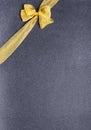 Golden decorative bow on the black background .Vertical shot, empty space for text