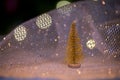 Golden decorative Christmas tree and sparkling bokeh against the background of a Christmas tree in lights