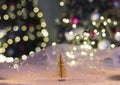 Golden decorative Christmas tree and sparkling bokeh against the background of a Christmas tree in lights