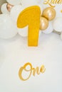 golden digit is one of foam against background of photo zone with balloons