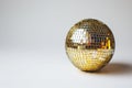 Golden disco ball with reflections on a light background with copy space. Ideal for themes related to dance, party, and