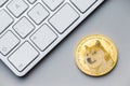 Golden dogecoin coin. Cryptocurrency dogecoin. Doge cryptocurrency and computer keyboard