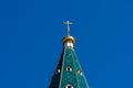 Golden dome with a cross on the green roof of the Russian Orthodox Church Royalty Free Stock Photo