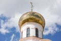 A golden dome with a cross shines in the sun. Royalty Free Stock Photo