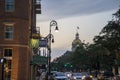 The golden dome of Savannah City Hall with cars driving on the street and people walking on the sidewalk Royalty Free Stock Photo