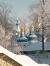 Golden domes of the church and belfry of Holy Dormition Pskovo Pechersky Male Monastery in the town of Pechora, Pskov Region,