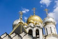 Golden domes with crosses of an orthodox temple on the background of bright blue sky. Snow-white facade. Christian faith