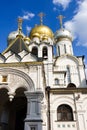 Golden domes with crosses of an orthodox temple on the background of bright blue sky. Snow-white facade. Christian faith