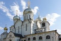 Golden domes with crosses of an orthodox temple on the background of bright blue sky. Snow-white facade. Christian faith