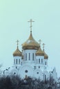 Golden domes and crosses of a white Orthodox Christian church against the sky Royalty Free Stock Photo