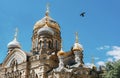 Golden domes of an Orthodox Church against a blue sky, a dove in the sky Royalty Free Stock Photo