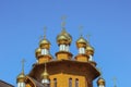 Golden domes of wooden church on bright blue sky background Royalty Free Stock Photo