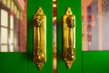 Golden door handles on the green wooden door. Abstract background with space. Royalty Free Stock Photo