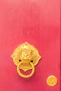 Golden door knocker in the shape of lion with ring on a red wood Royalty Free Stock Photo