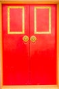 Golden door knocker in the shape of lion with ring on a red wooden door. Close up wooden Chinese style red door with lion head Royalty Free Stock Photo