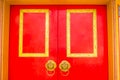 Golden door knocker in the shape of lion with ring on a red wooden door. Close up wooden Chinese style red door with lion head Royalty Free Stock Photo