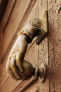 Golden doorknocker with hand shape on old wooden door Royalty Free Stock Photo