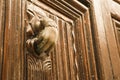 Golden doorknocker with hand shape on old wooden door Royalty Free Stock Photo