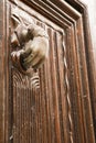 Golden doorknocker with hand shape on old wooden door Royalty Free Stock Photo