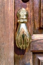 Golden doorknocker with hand shape