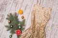 Golden Dress With Sequins On A Wooden Background, Spruce Branch And Balls And Citrus