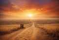 A golden dry desert field without vegetation in the rays of the sunset of the summer sun. A dirt road