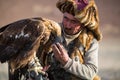 Golden Eagle Hunter, while hunting to the hare holding a golden eagles on his arms in desert mountain of Western Mongolia.