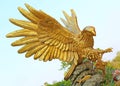 Golden eagle statue against blue sky