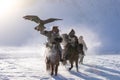 Golden eagle during the winter Mongolia local men riding on horses around the mountains covered with snow Royalty Free Stock Photo