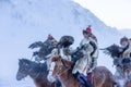 Golden eagle during the winter Mongolia local men riding on horses around the mountains covered with snow Royalty Free Stock Photo