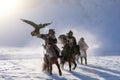 Golden eagle during the winter Mongolia local men riding on horses around the mountains covered with snow Royalty Free Stock Photo