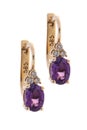 Golden earrings with diamonds and amethysts, isolated on the white Royalty Free Stock Photo