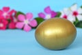 Golden Easter egg and colorful flowers Royalty Free Stock Photo