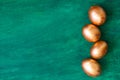 Golden Easter eggs and golden branches, reeds on a green watercolor background. Banner. Layflat. Space for text