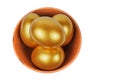 Golden Easter eggs in a clay bowl isolated on a white background Royalty Free Stock Photo