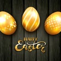 Golden Easter eggs with pattern on black wooden background Royalty Free Stock Photo