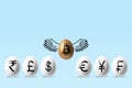 Golden egg with a bitcoin sign flying above white eggs with currency signs on blue background. Minimal investment concept