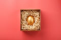 Golden egg in a box on a pink background. The concept of exclusivity, best choice, prize, special surprise, expensive gift Royalty Free Stock Photo