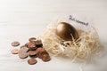 Golden egg and card with word RETIREMENT in nest near coins on wooden background Royalty Free Stock Photo