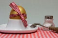 Golden egg in an egg cup on a red patterned napkin Royalty Free Stock Photo