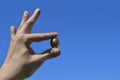 Golden egg in hand against blue sky. Royalty Free Stock Photo