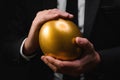 Golden egg in hands of elegant businessman as symbol of guaranteed success, profit or wealth Royalty Free Stock Photo