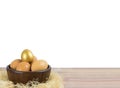 Golden Egg on pile eggs bowl on table.