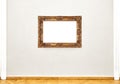 Golden empty painting frame hanging on exhibition wall