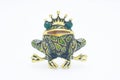 Golden enamelled brooch frog wearing a crown isolated on white