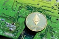 Golden Ethereum coin lying on computer motherboard, cryptocurrency investing, blockchain technology